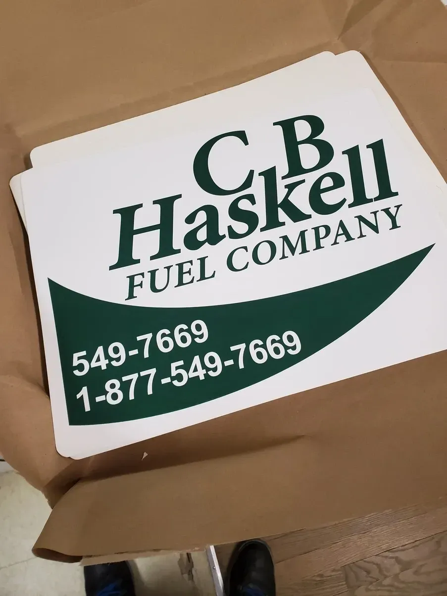 White signs with green text for C.B. Haskell Fuel Company, with phone numbers.