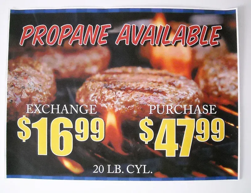 Sign: Propane available. Exchange $16.99, Purchase $47.99. Burgers grilling.