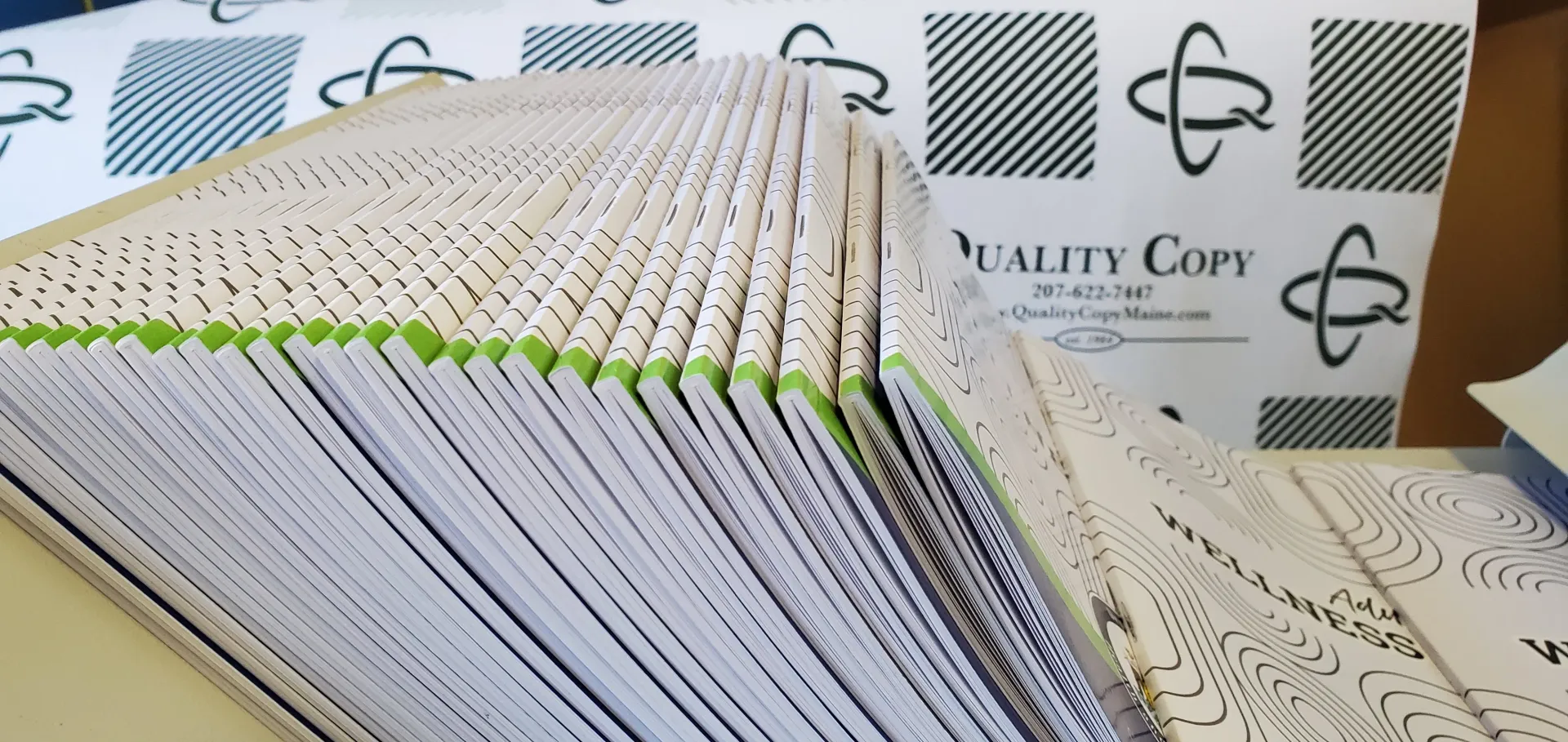 Piles of printed papers, stacked with green edges visible.
