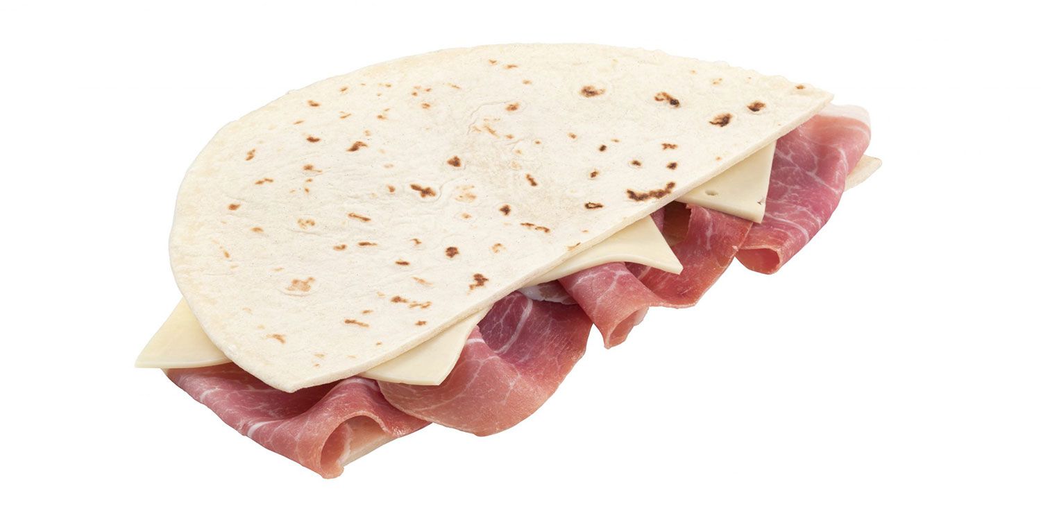 Un panino con tortilla, prosciutto e formaggio su uno sfondo bianco.