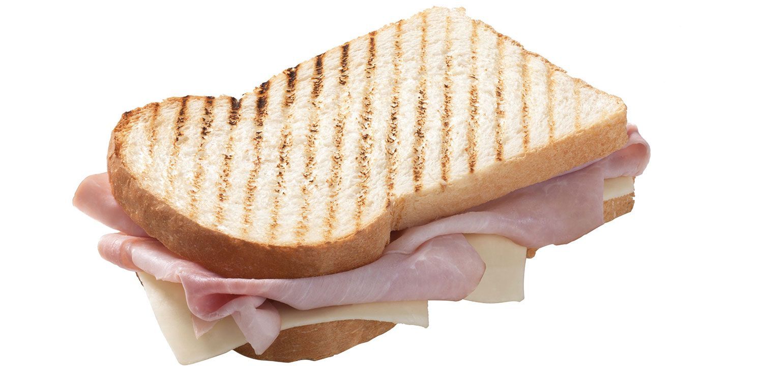 Un panino grigliato con prosciutto e formaggio su uno sfondo bianco
