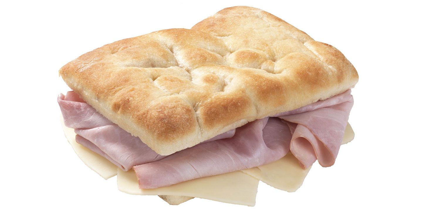 Un panino al prosciutto e formaggio su una fetta di pane su uno sfondo bianco.