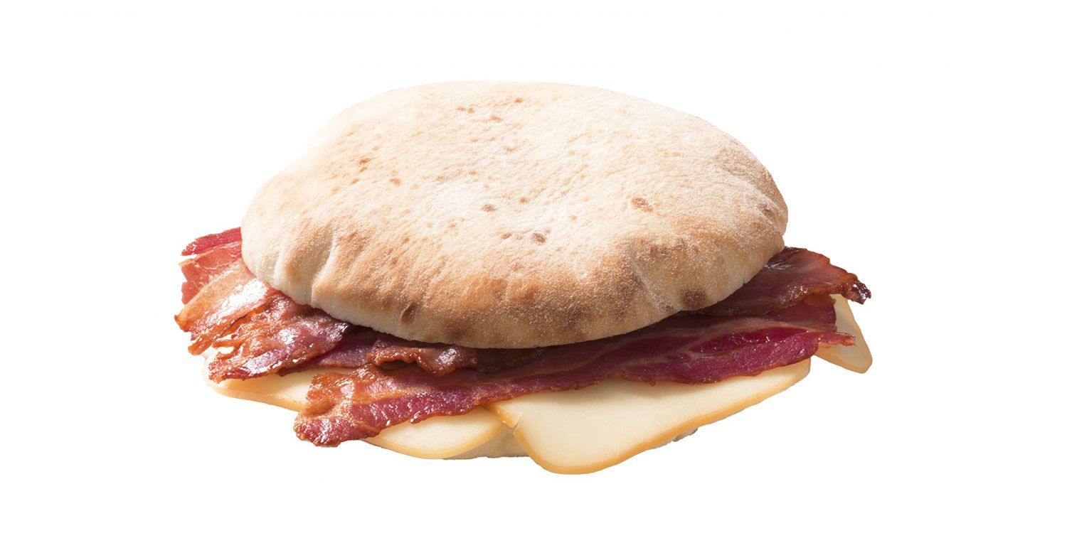 Primo piano di un panino con bacon e formaggio su sfondo bianco.