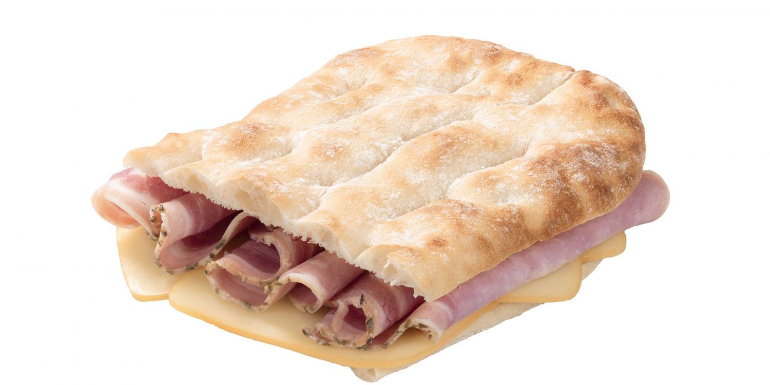Un panino con prosciutto e formaggio su un pane pita su uno sfondo bianco.