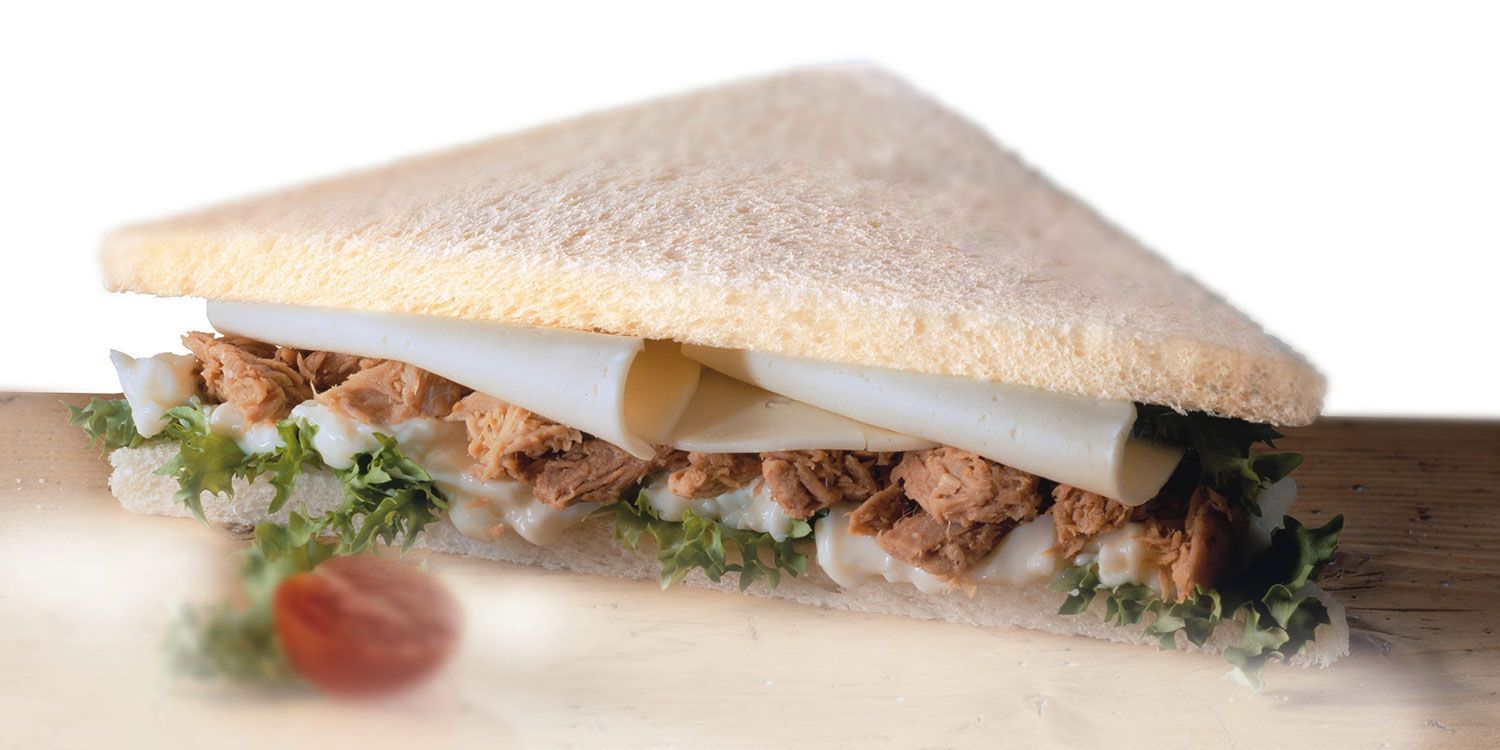 Un panino con tonno, formaggio e lattuga su un tavolo di legno.