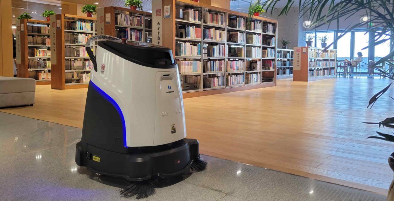 A white and black robot is sitting on a table in a room.