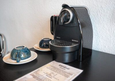 Black espresso machine, two blue cups on saucers, and a 