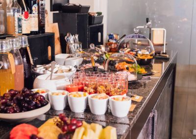 Breakfast buffet with fruit, yogurt, and various toppings on a counter.