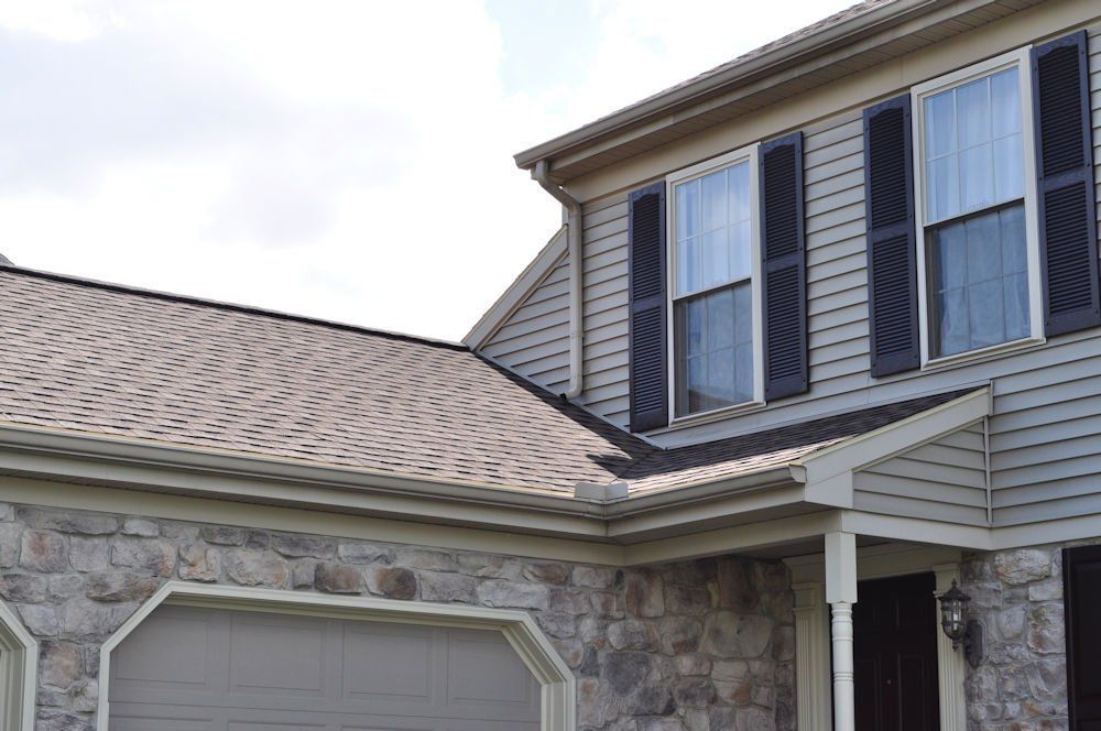 A house with a garage and black shutters on the windows