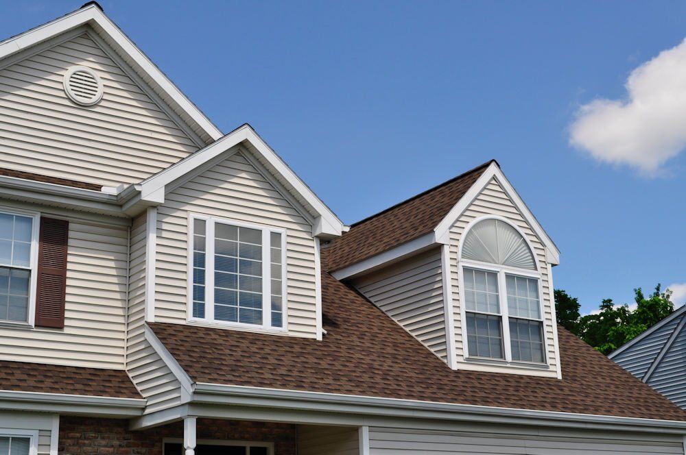 A house with a brown roof and white siding