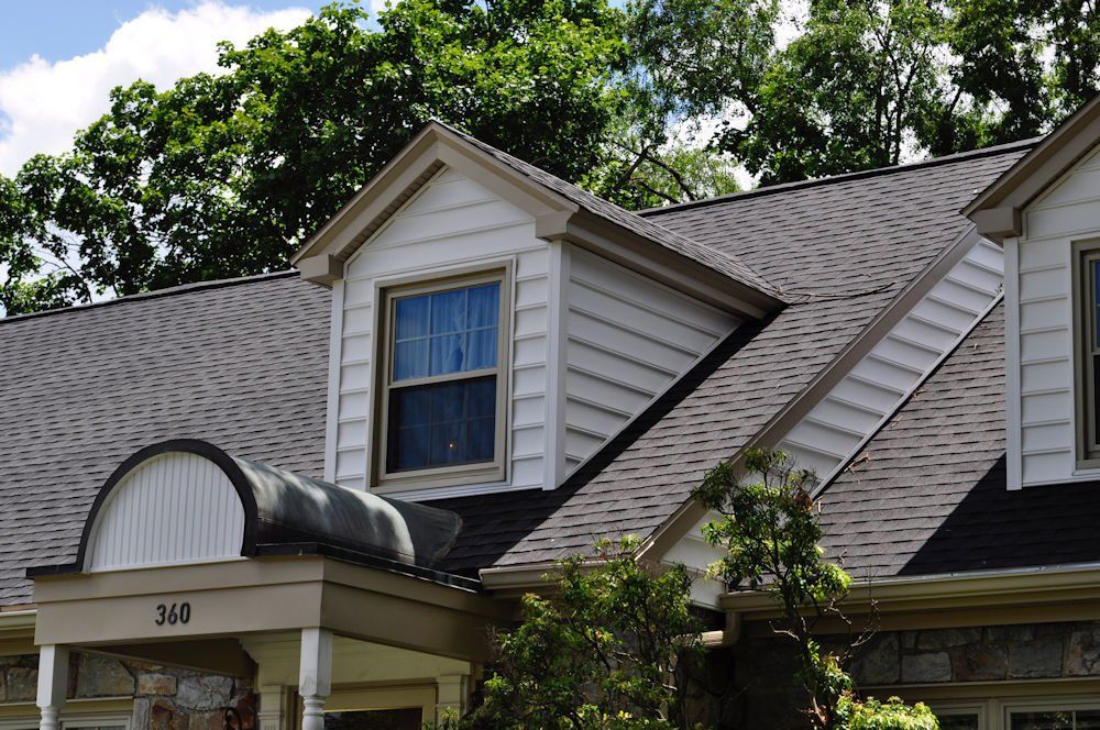 A white house with a black roof and a window