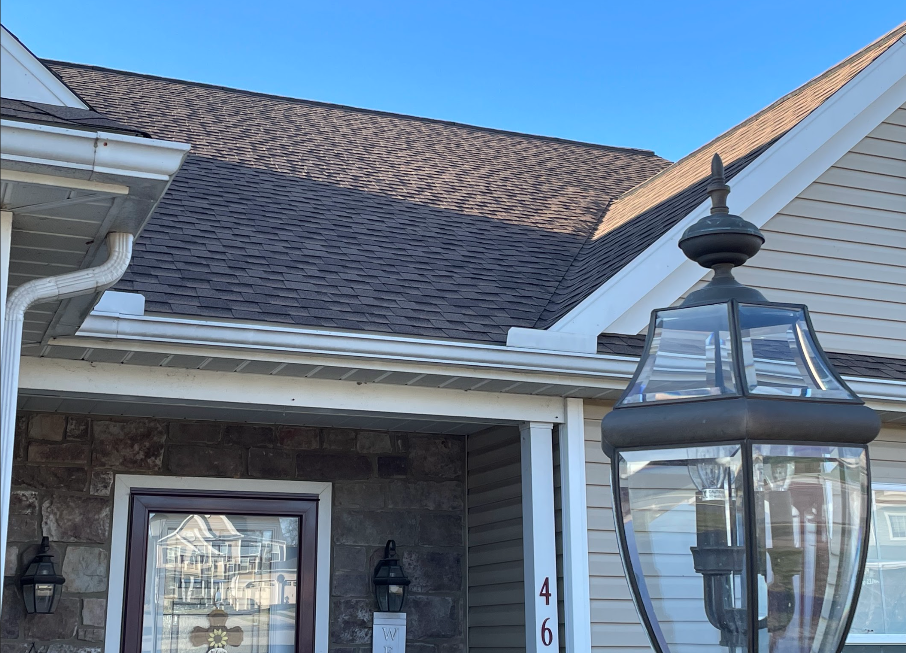 The front of a house with a lamp on the porch.