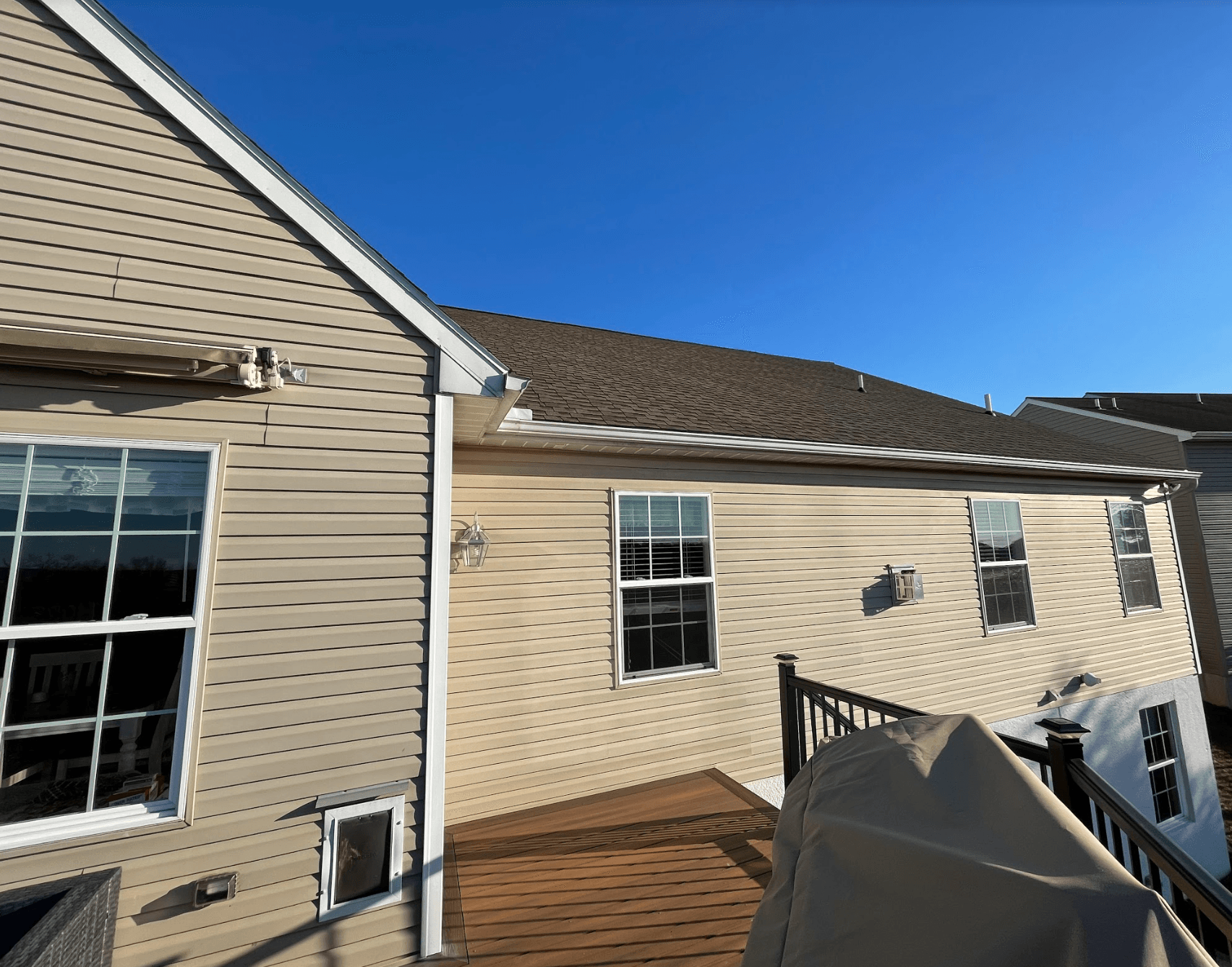 A house with a deck and a blue sky in the background