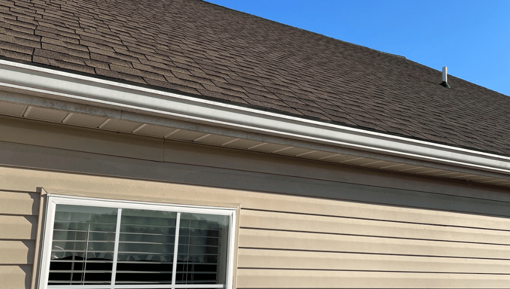 A house with a window and a brown roof replaced by Sunnyside Roofing LLC in Lancaster PA.