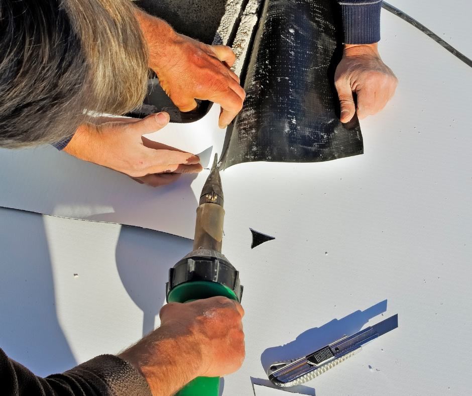 A man is using a tool to cut a piece of black tape