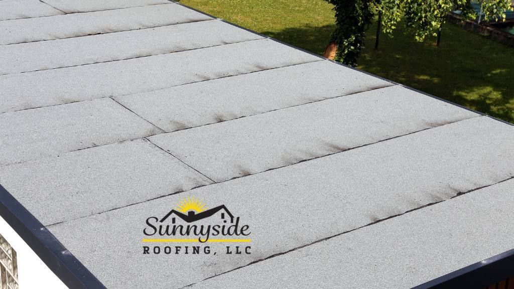 A sunnyside roofing llc logo is on the flat roof of a building
