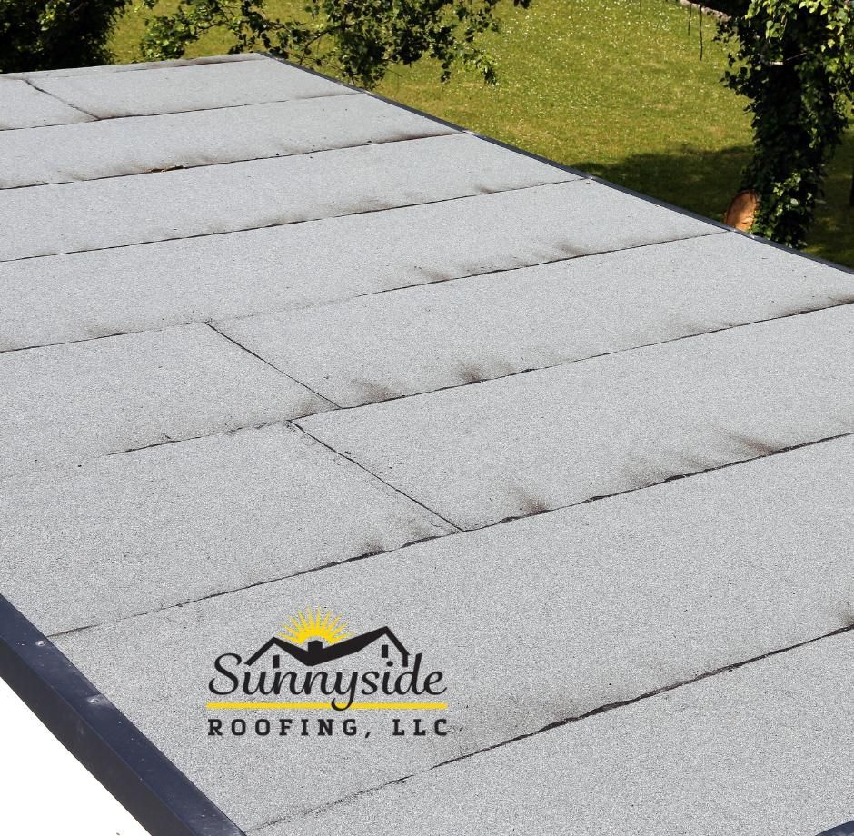 A sunnyside roofing logo is on top of a new flat roof installed in York PA