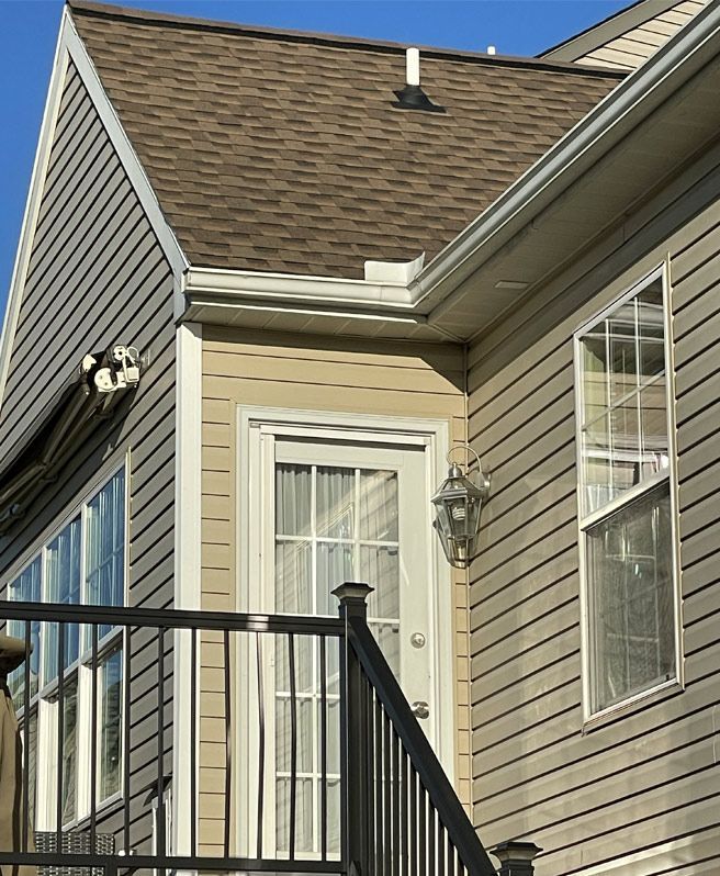 A house with a balcony and stairs leading up to it with new siding