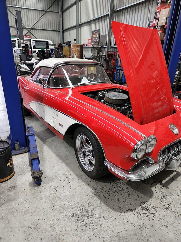 A Red Car with The Hood Up Is Parked in A Garage — Genesis Automotive Services in Lavington, NSW