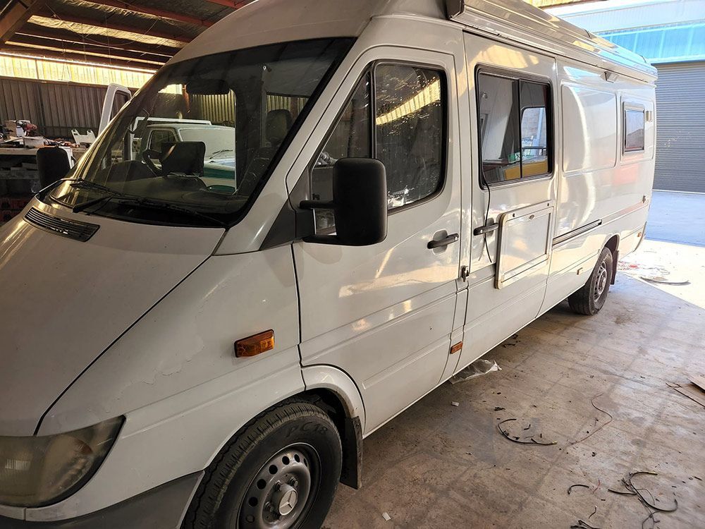 A White Van Is Parked in A Garage — Genesis Automotive Services in Lavington, NSW