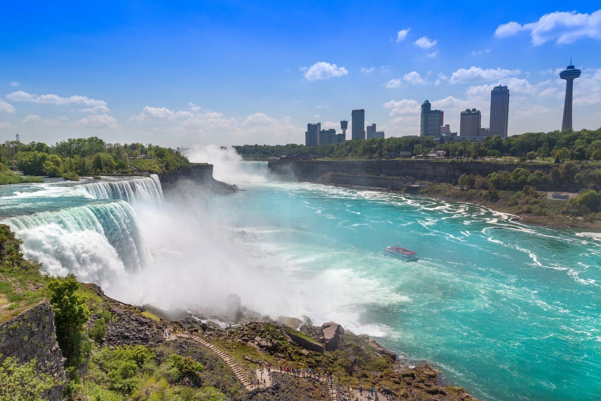 waterfall with city skyline in background