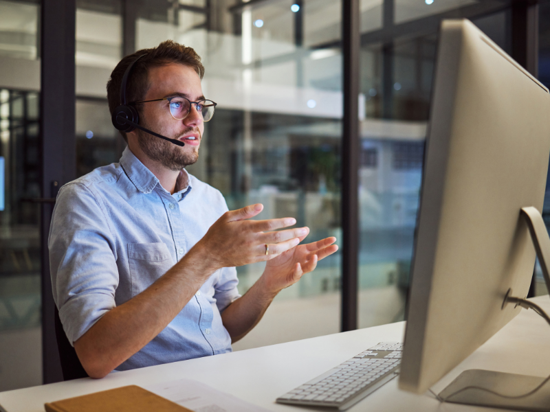a man on a phone call looking at a computer