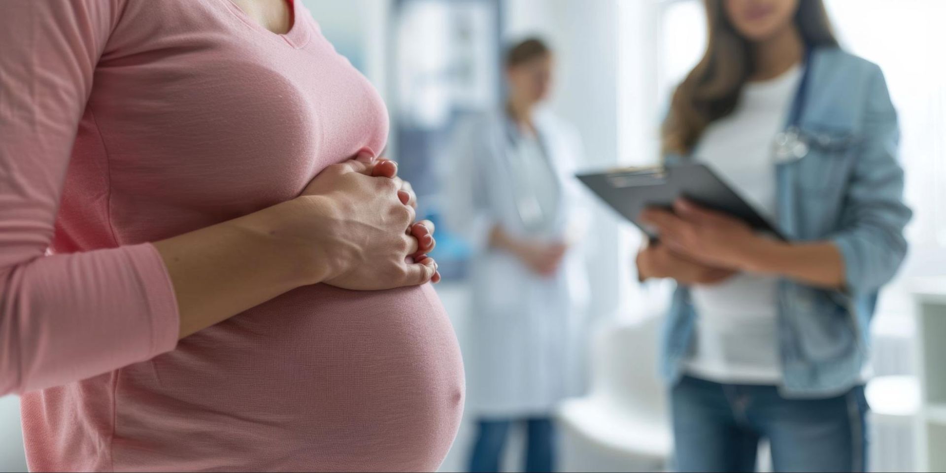 pregnant woman holding belly with medical staff watchin