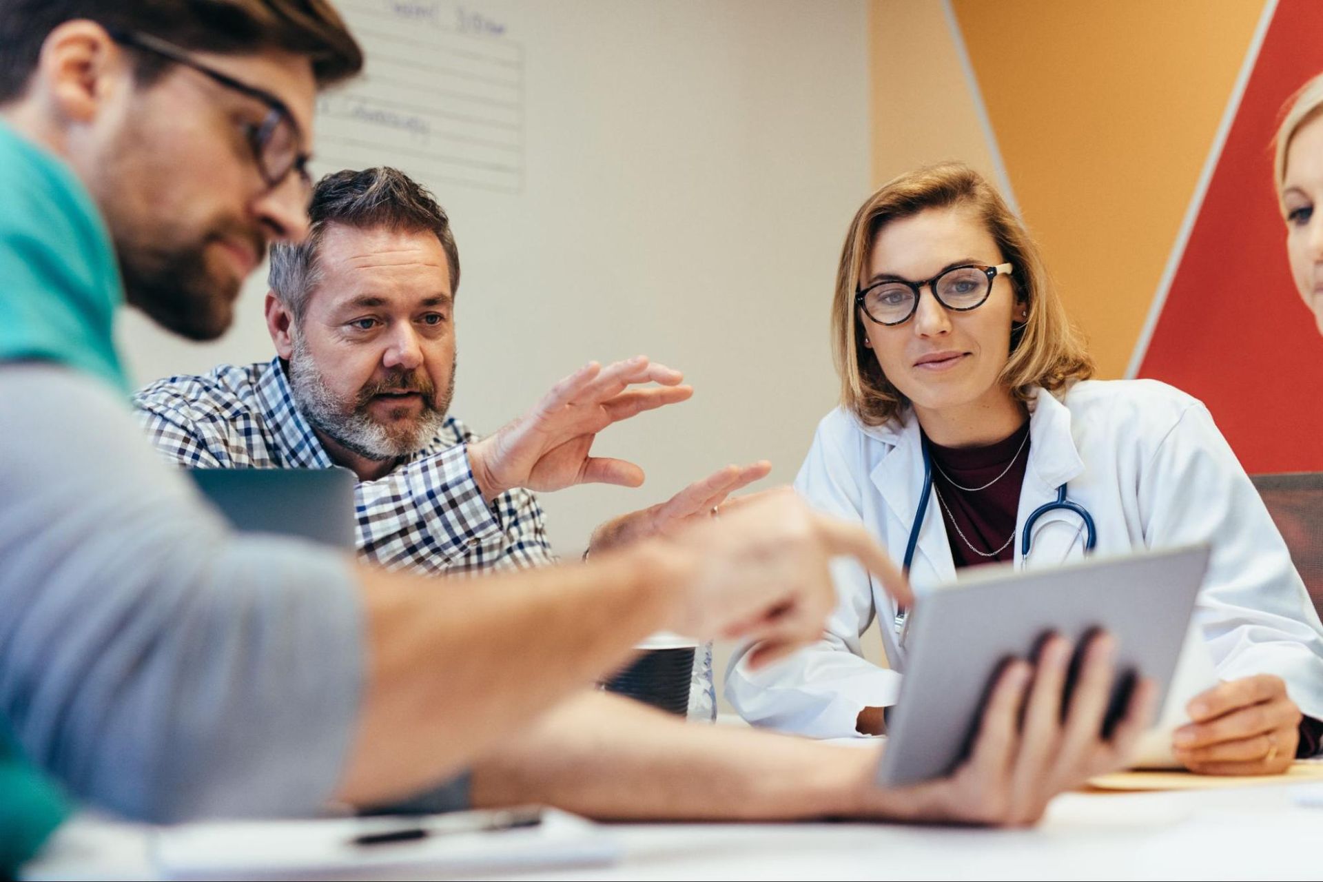 team of medical staff view a tablet device