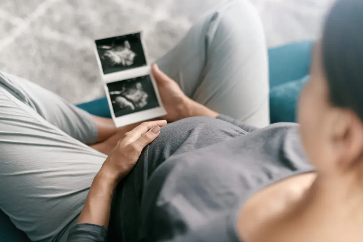 Woman looking at ultrasound scan of her baby