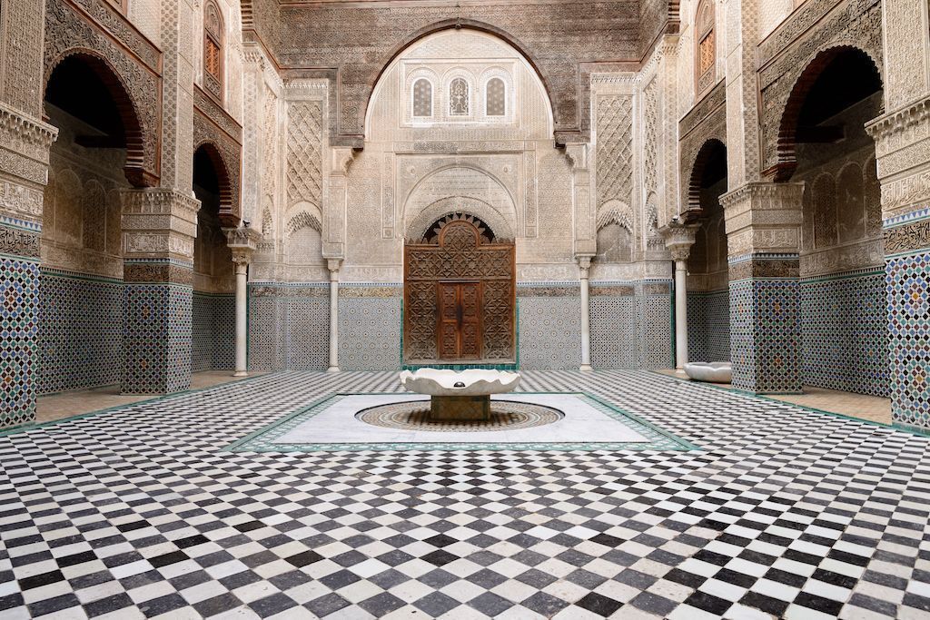 An ornate riad courtyard in Marrakech, showcasing traditional Moroccan architecture with zellij tile