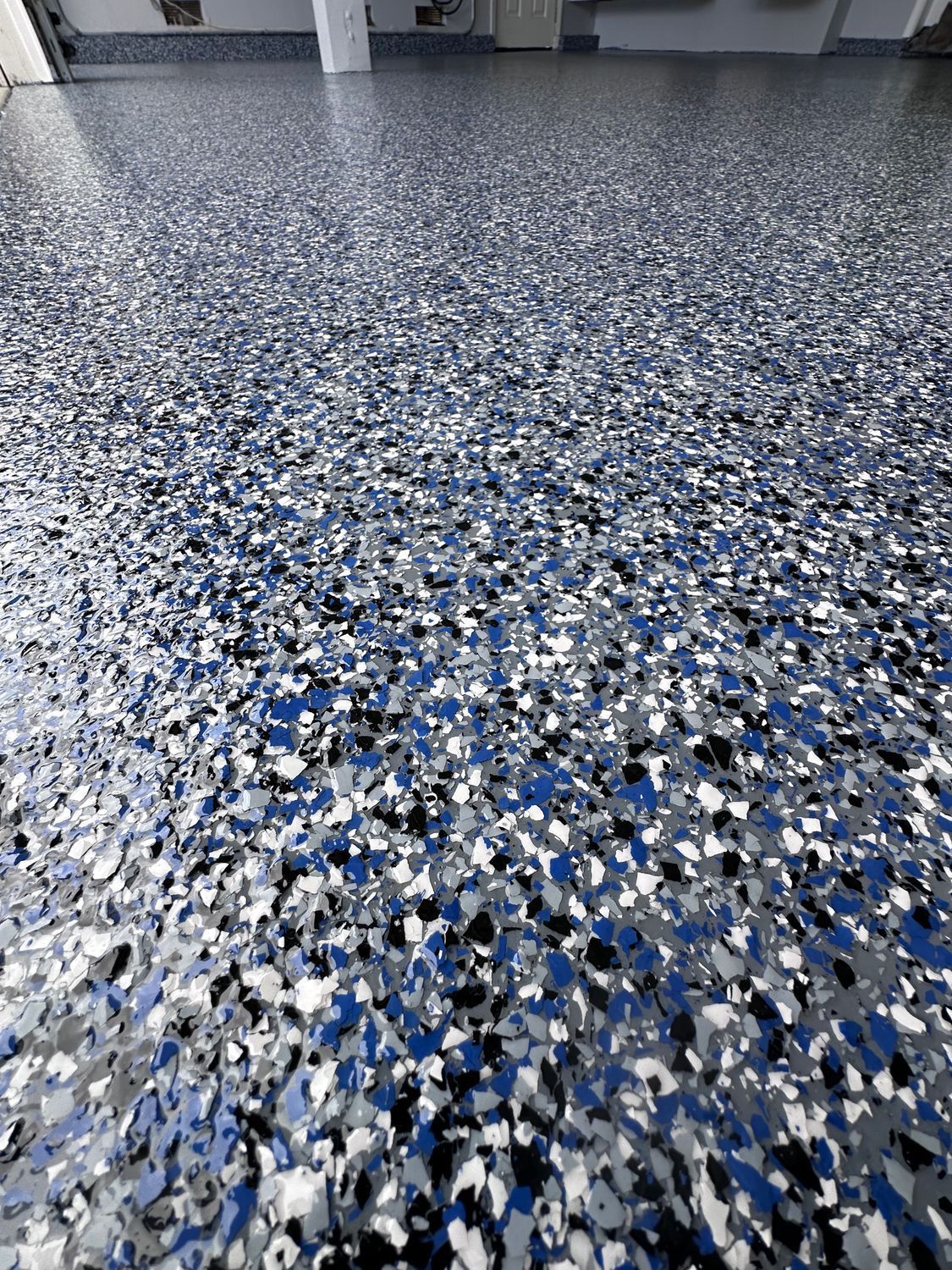 Epoxy garage floor with blue, gray, and white chips.