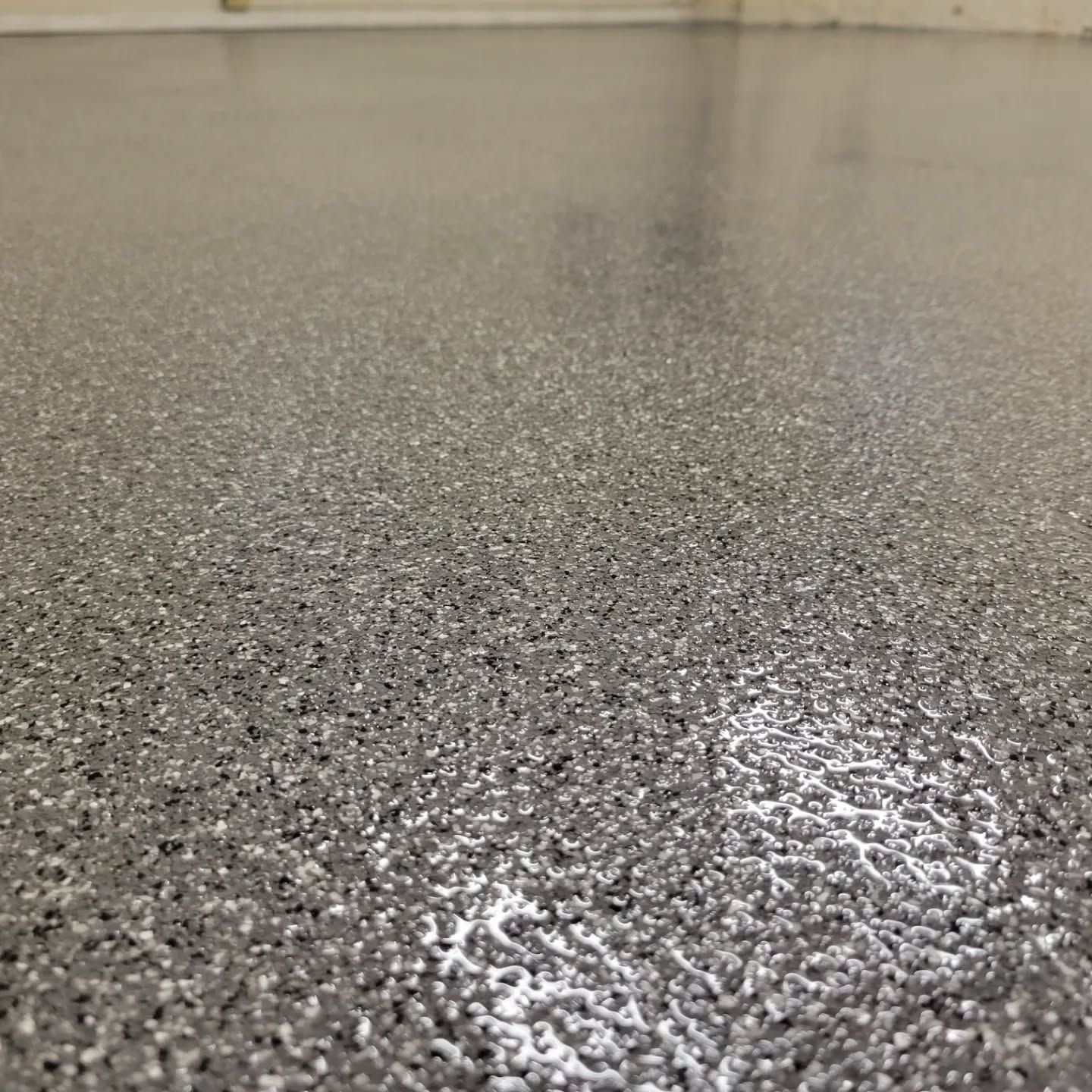 Gray speckled epoxy floor with a glossy finish.