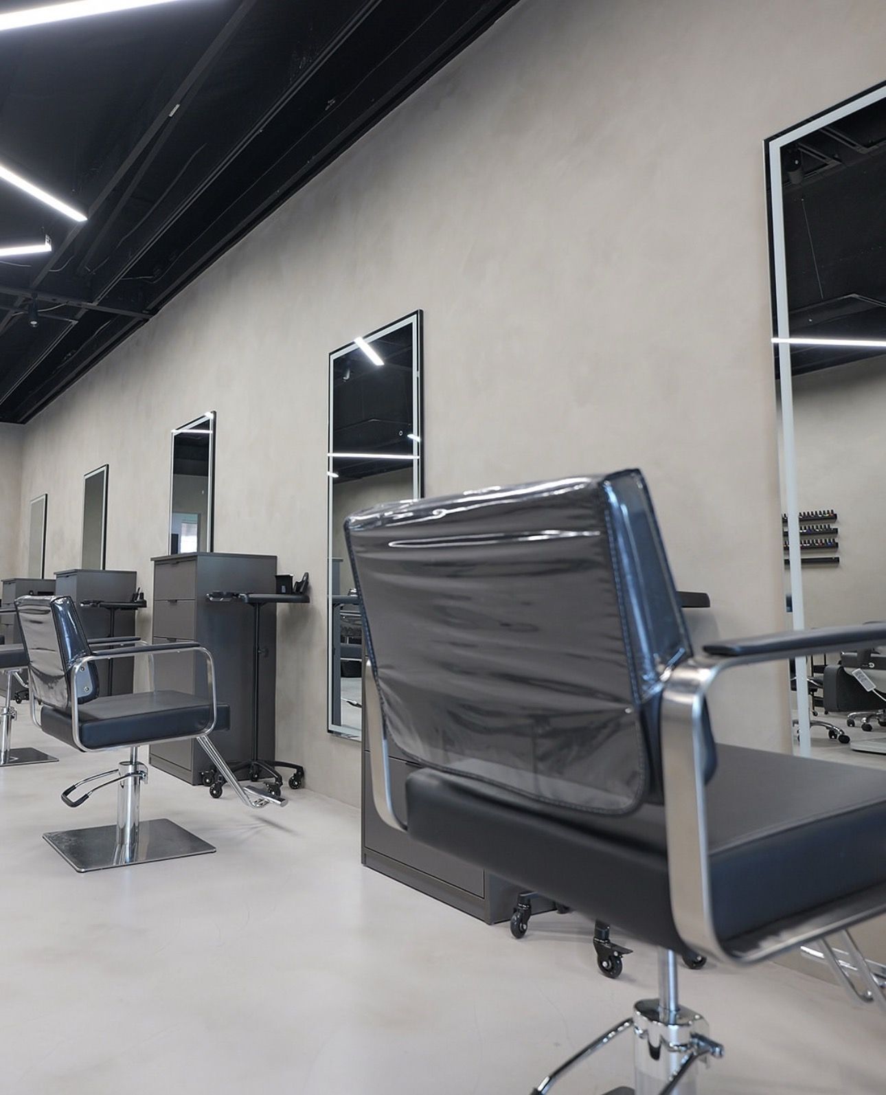 A commercial kitchen with stainless steel appliances, shelves with supplies, and dark blue flooring.