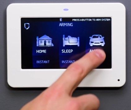 Hand touching security system touchscreen, selecting