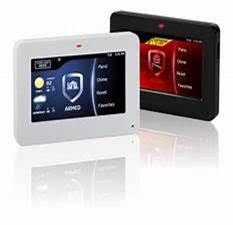 Two security system control panels, white and black, display touch screen menus.