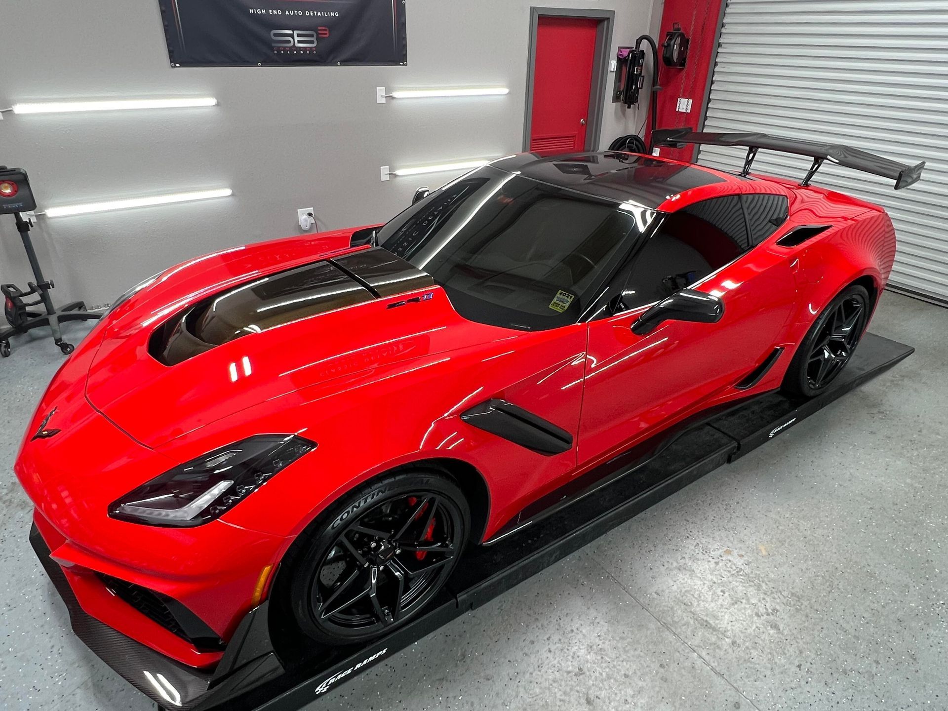 A red corvette zr1 is parked in a garage.