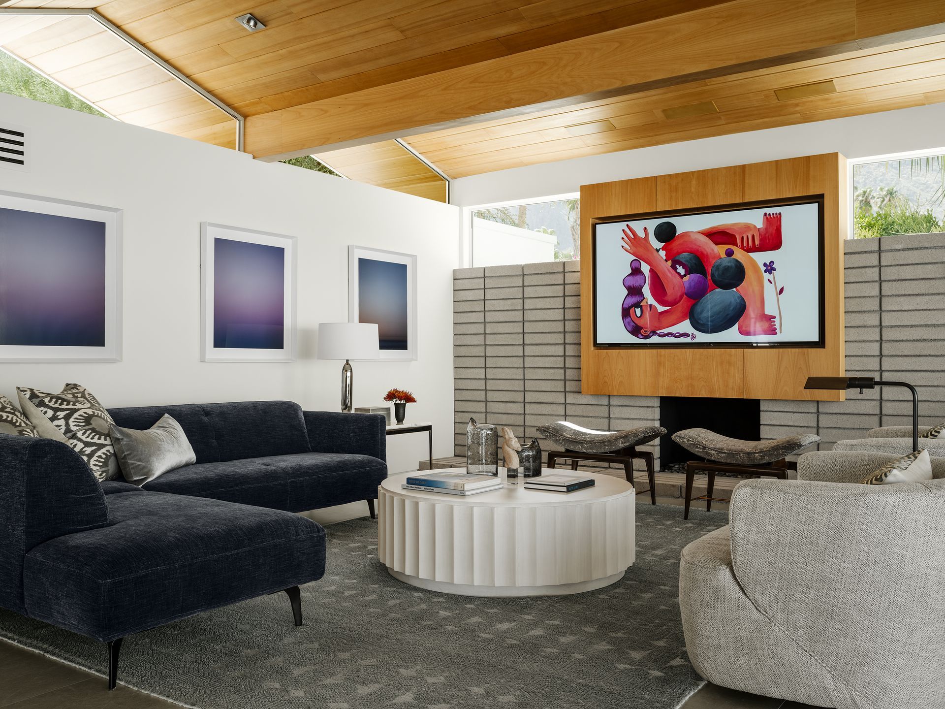 a living room with a couch , chairs , coffee table and television .