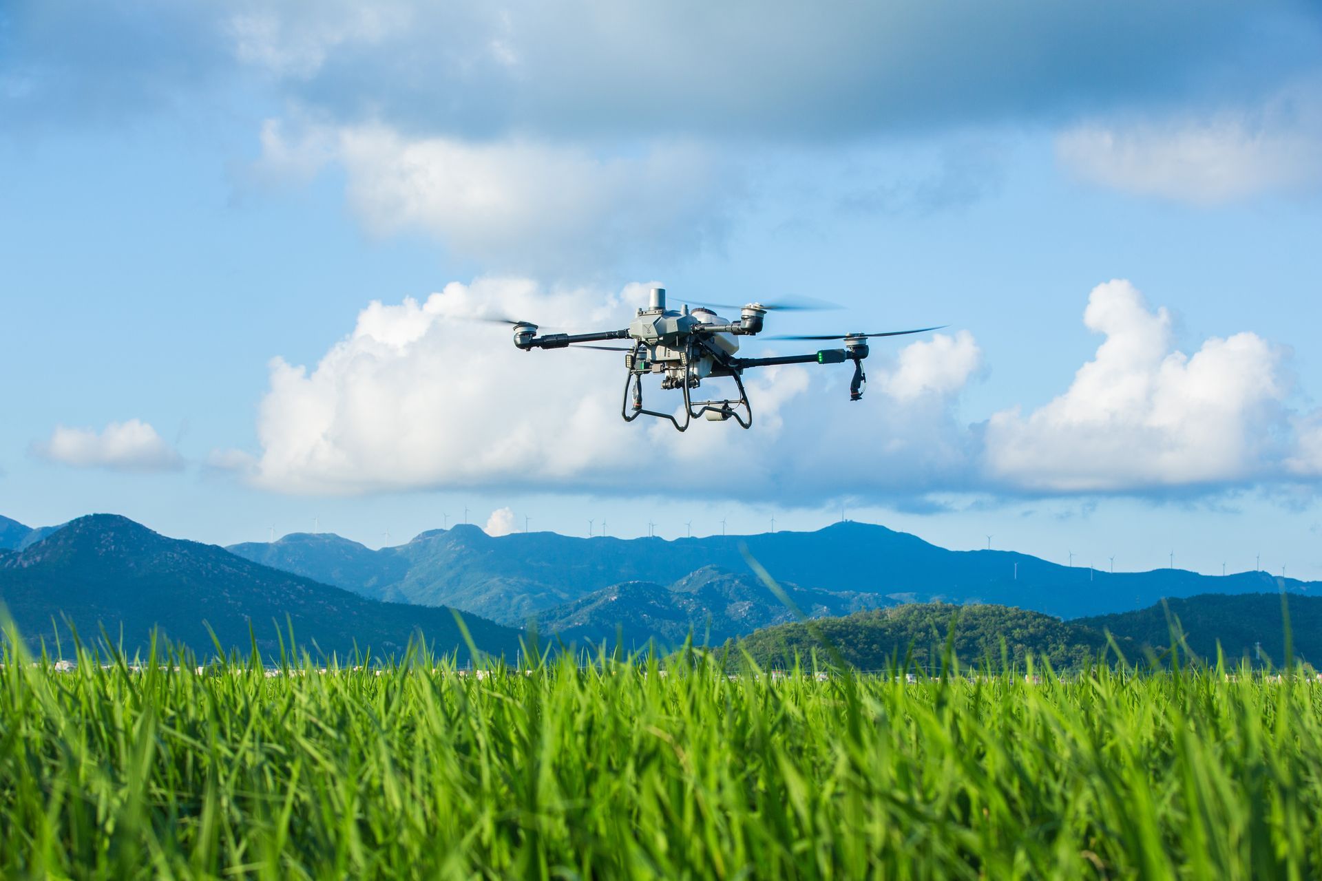 Talos T60X sprays a cloud of mist over a lush green orchard.