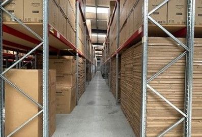 A small storage unit with red doors and a couch in it.