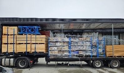 A pallet truck is carrying boxes in a warehouse.