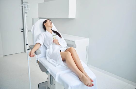 A woman examines her reflection in a mirror at a premier personalized medical care clinic.