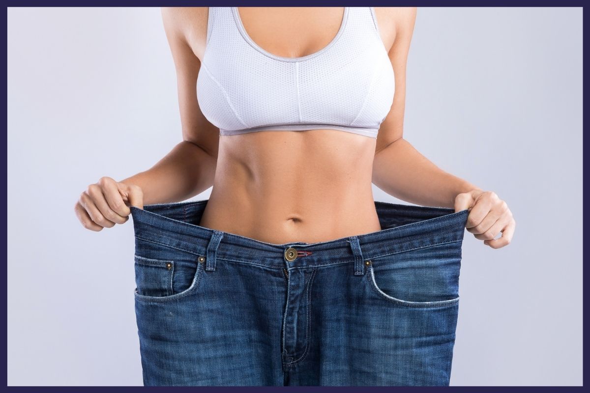 A woman holds up her jeans with the text 