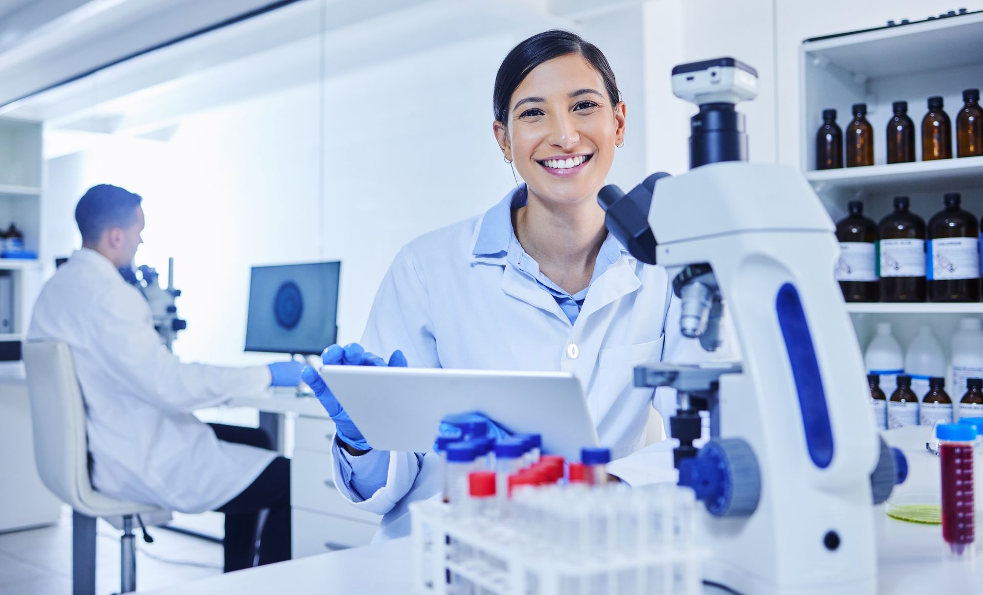 Doctor smiling, reviewing chart with patient in office. White coat, stethoscope, bright setting.