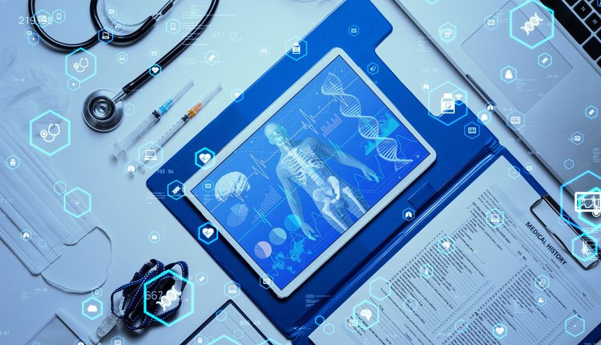 Medical workspace with tablet showing a human body diagram, stethoscope, syringes, and a laptop.