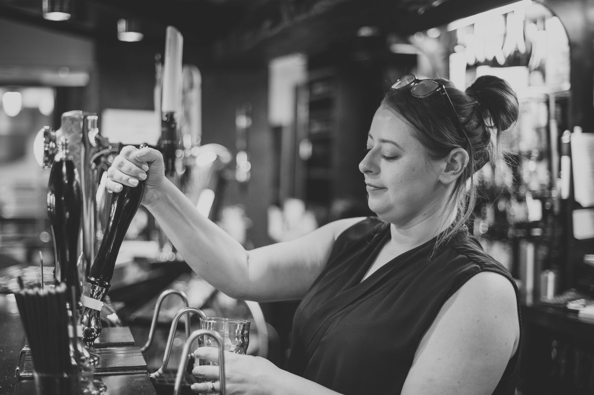 Bartender pulling a beer tap at a bar. at the Boot & Shoe Waterfoot, Rossendale