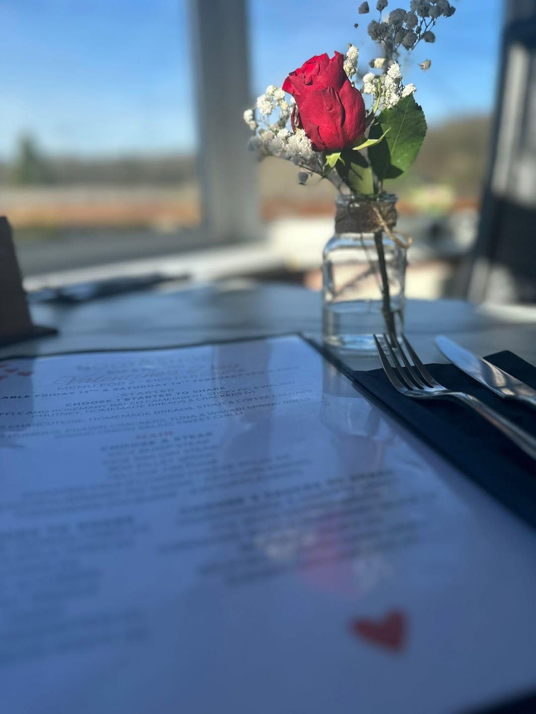 Red rose in glass vase on a restaurant table with a menu, Valentine's Day Menu at the Boot & Shoe Waterfoot, Rossendale