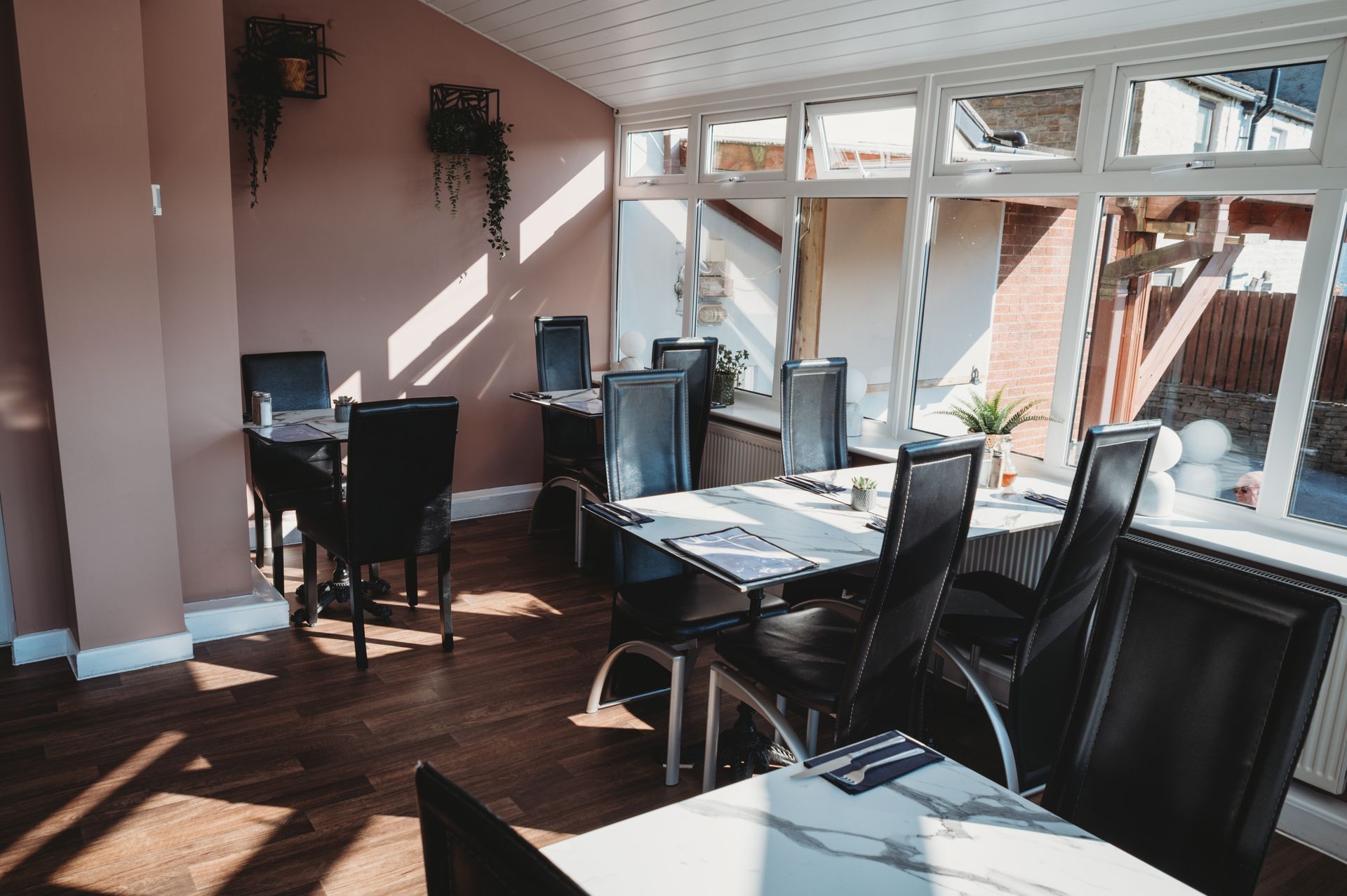 Restaurant dining and large windows. Soft pink walls. Comfortable surroundings for your special event.