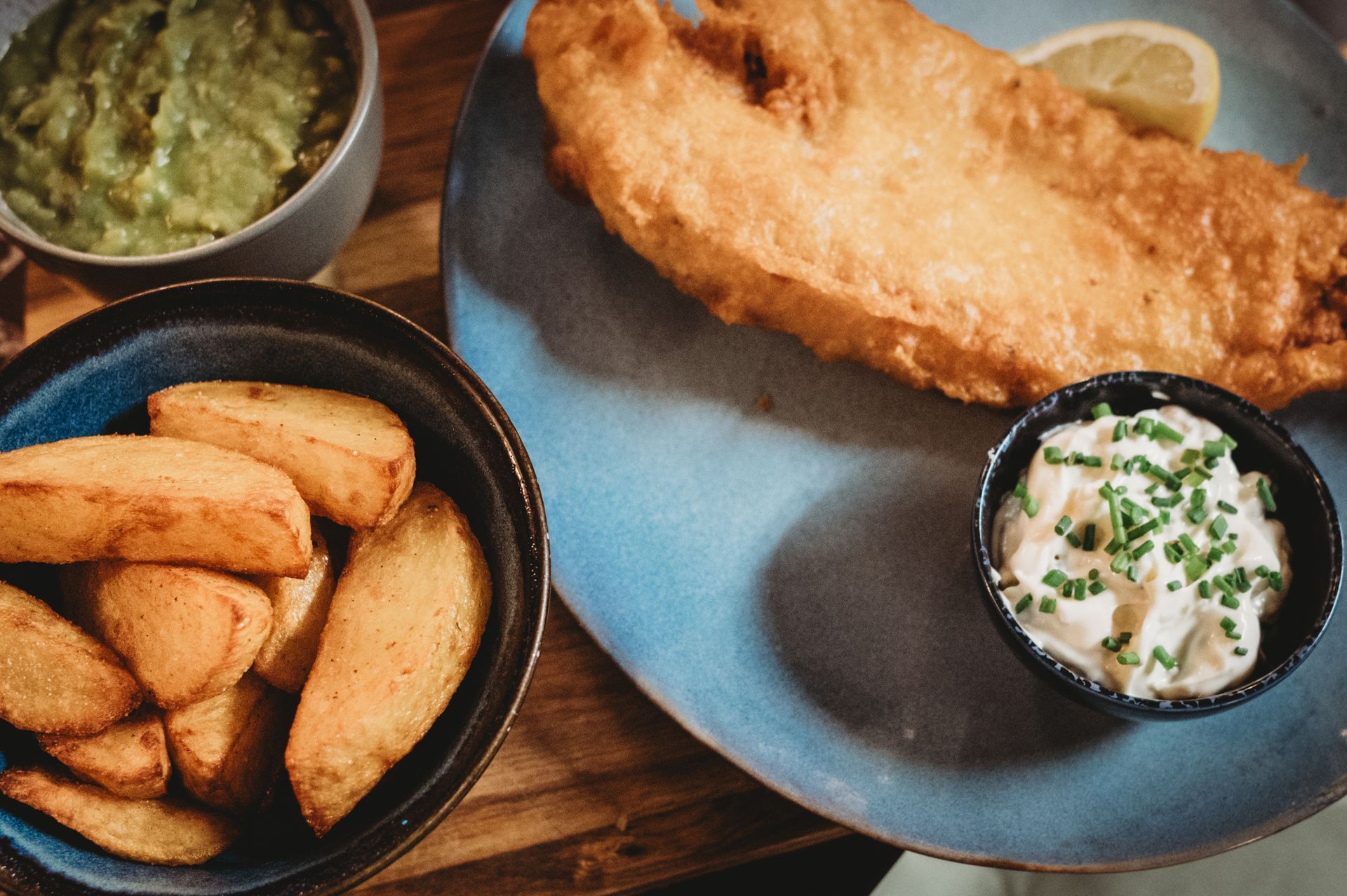 Sausages wrapped in bacon with roasted cabbage and mashed potatoes, served in a rich sauce.