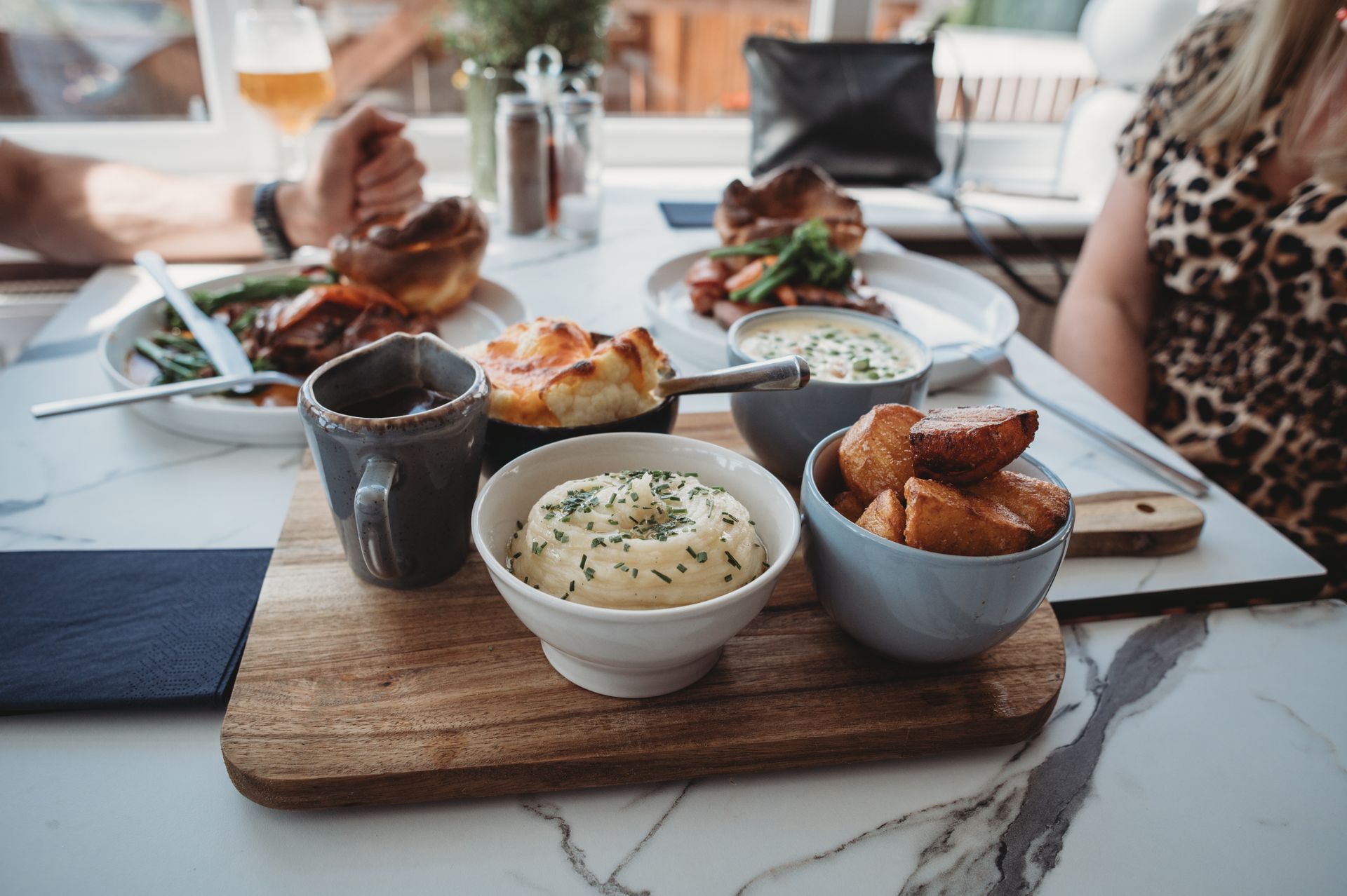 Table of food, including roast beef with Yorkshire pudding and sides.