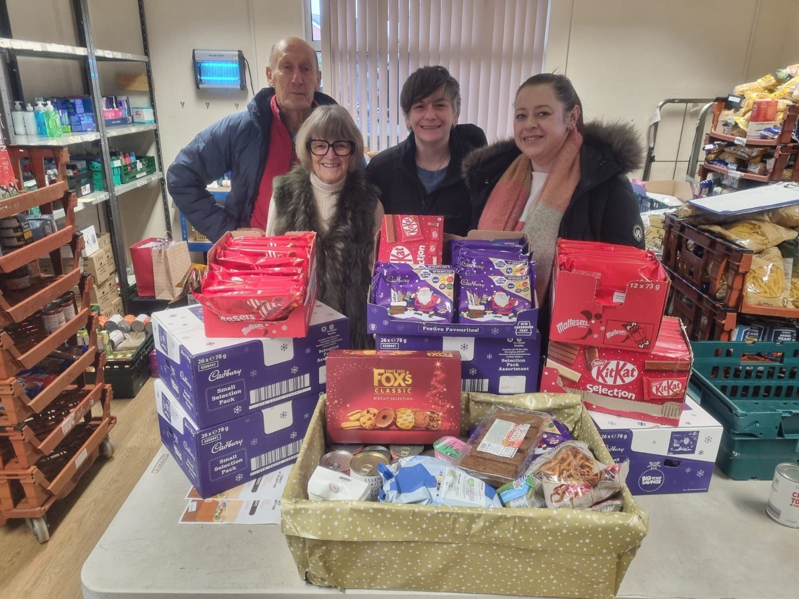 Donating boxes of chocolate and a gift basket in a pantry setting. Donated to Raft Foundation from the Boot & Shoe